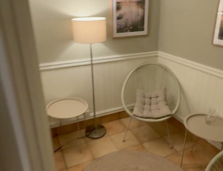 Relaxhörnan på Pensionat Enehall med fåtöljer, rund matta och en mjukt glödande lampa