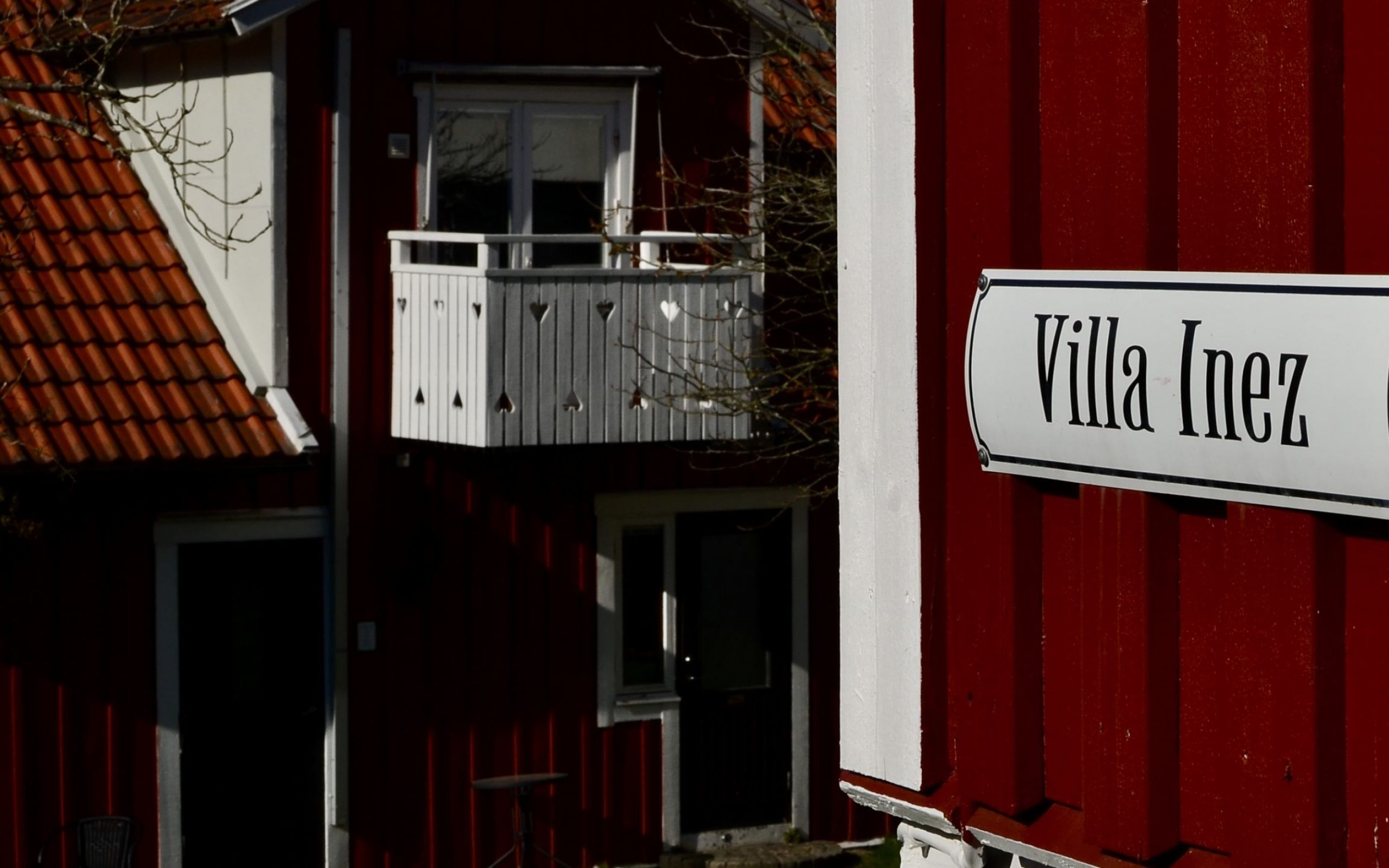 Villa Inez med röd träfasad och vit balkong